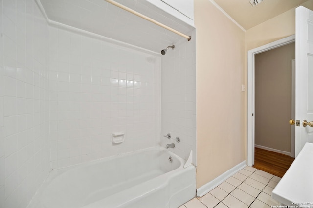 bathroom featuring tiled shower / bath combo, tile patterned floors, and vaulted ceiling