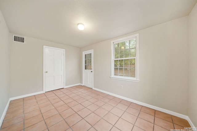 spare room featuring light tile patterned flooring