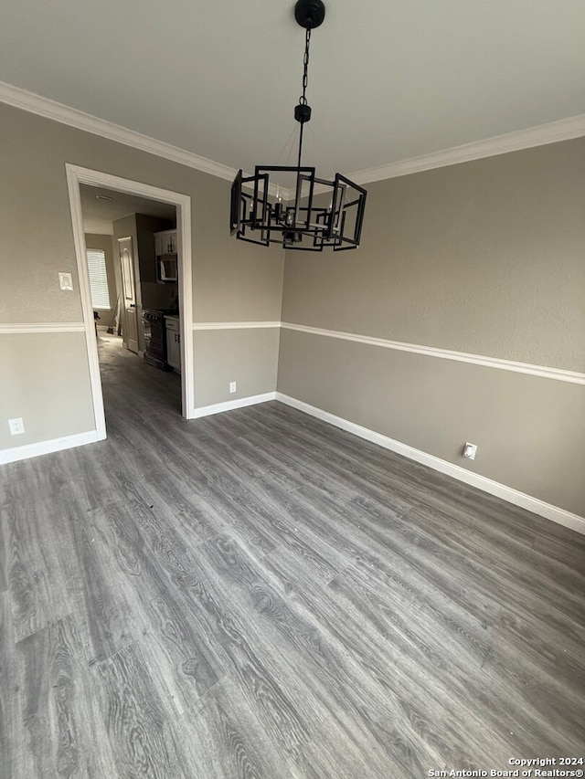 unfurnished dining area with hardwood / wood-style floors, crown molding, and a notable chandelier