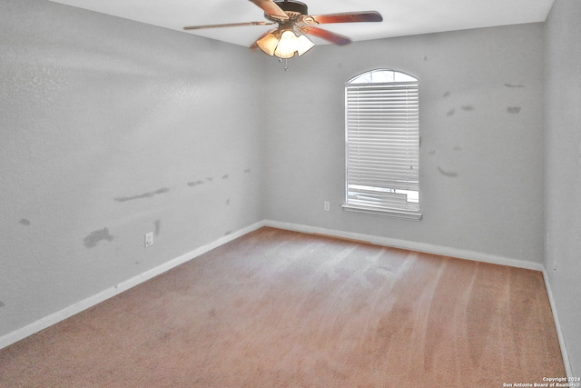 empty room featuring ceiling fan and light colored carpet