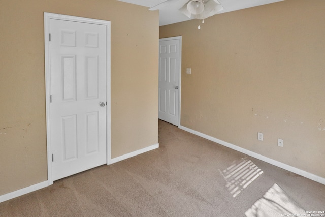 unfurnished bedroom featuring ceiling fan and light colored carpet