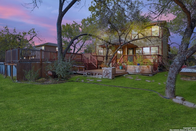 yard at dusk featuring a wooden deck