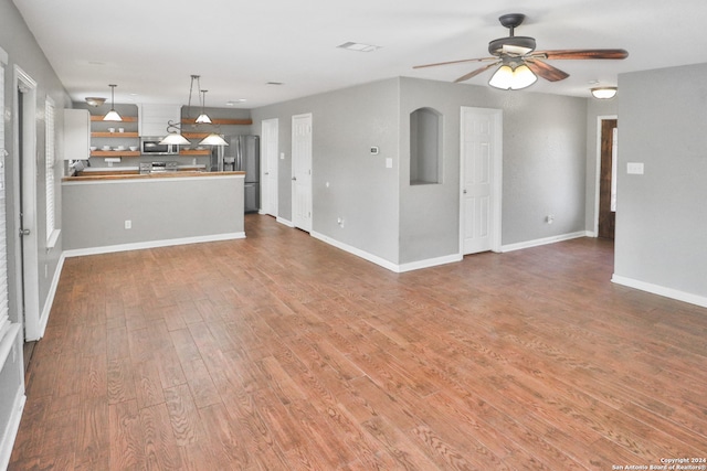 unfurnished living room with ceiling fan and hardwood / wood-style floors