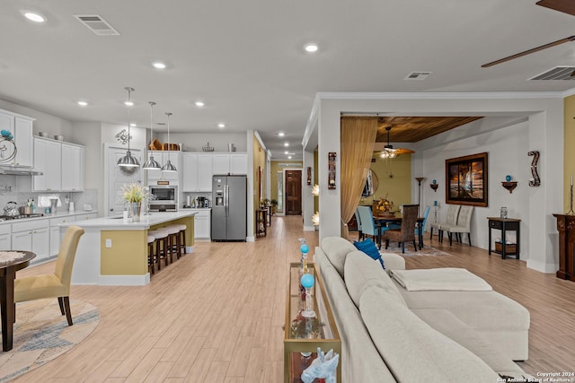 living room featuring ornamental molding, ceiling fan, and light hardwood / wood-style flooring