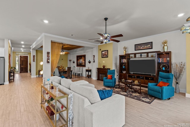 living room featuring light wood-type flooring, ceiling fan, and crown molding