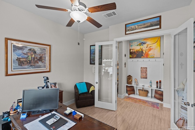 office with light hardwood / wood-style floors, ceiling fan, and french doors