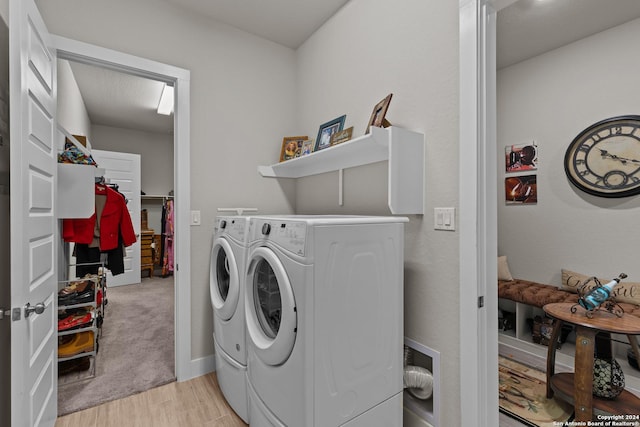 laundry area with washer and dryer and light wood-type flooring