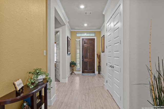 entrance foyer with light hardwood / wood-style floors and crown molding