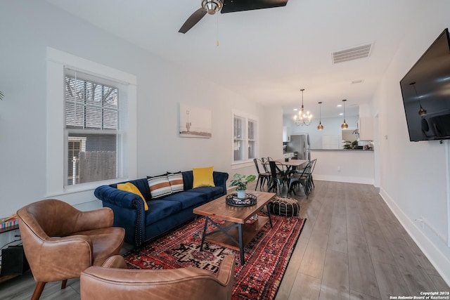 living room featuring hardwood / wood-style floors and ceiling fan with notable chandelier