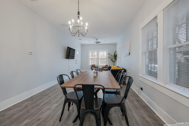 dining space featuring hardwood / wood-style floors and ceiling fan with notable chandelier