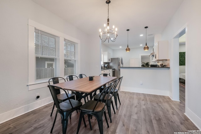 dining area featuring light hardwood / wood-style floors and a chandelier