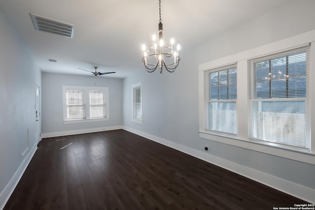 spare room with dark wood-type flooring and ceiling fan with notable chandelier