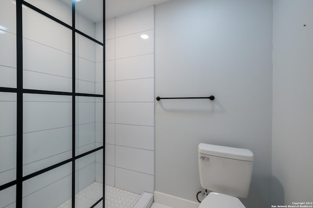 bathroom with toilet and a tile shower