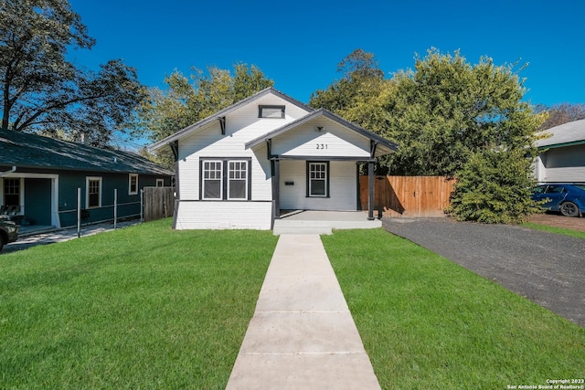 bungalow-style house featuring covered porch and a front yard