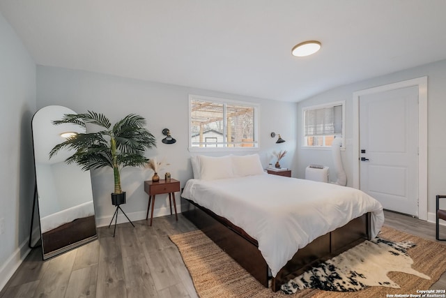 bedroom featuring hardwood / wood-style floors and vaulted ceiling