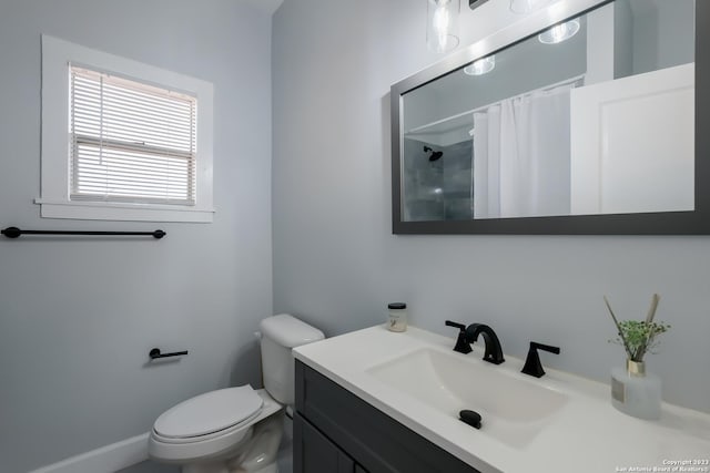 bathroom with curtained shower, vanity, and toilet