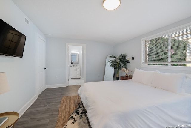 bedroom featuring dark hardwood / wood-style flooring and connected bathroom