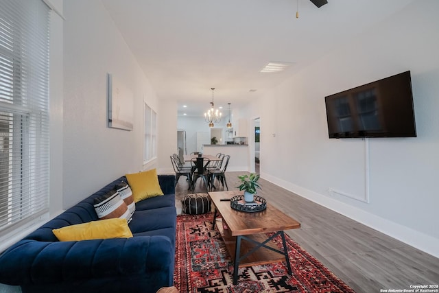 living room with a notable chandelier and wood-type flooring