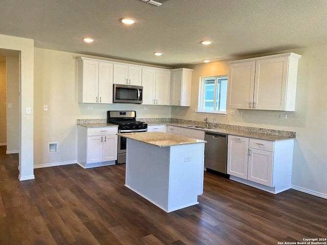 kitchen with white cabinets, stainless steel appliances, and a kitchen island