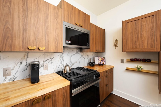 kitchen featuring backsplash, high end range, dark wood-type flooring, and wood counters