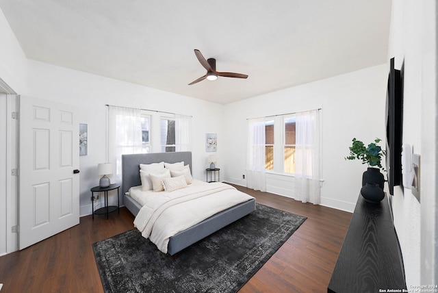 bedroom with dark hardwood / wood-style flooring and ceiling fan