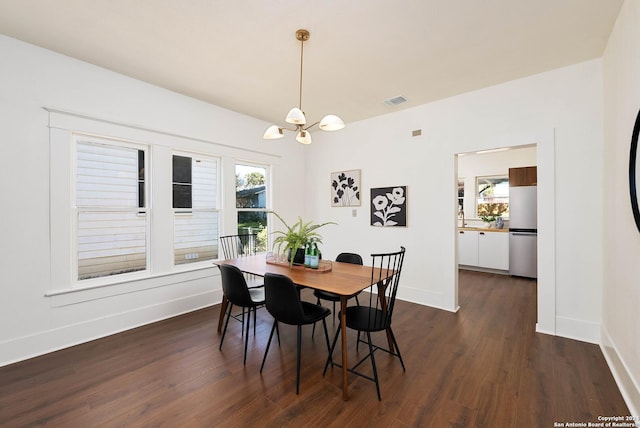 dining room featuring dark hardwood / wood-style flooring and an inviting chandelier