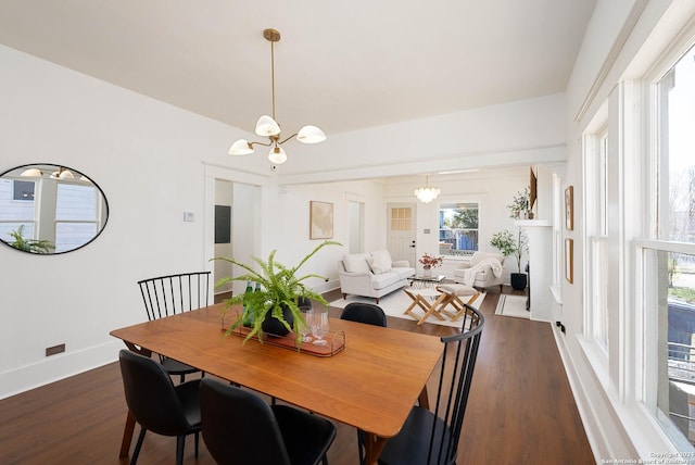 dining area featuring dark hardwood / wood-style flooring and a notable chandelier