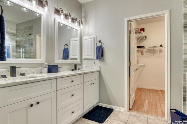 bathroom with tile patterned flooring, vanity, and a shower with door