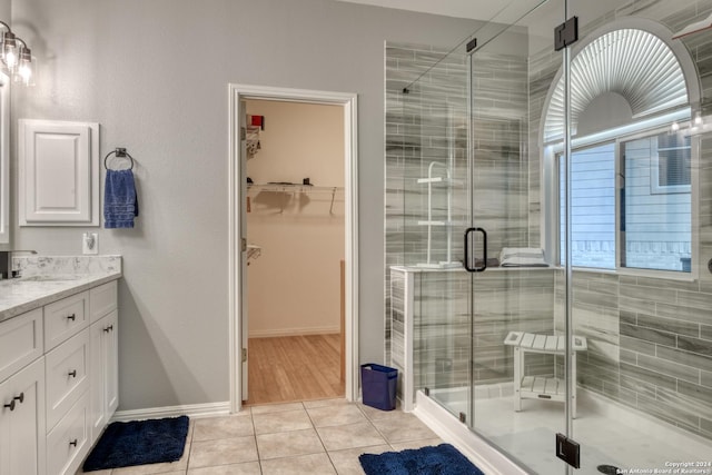 bathroom featuring vanity, a shower with shower door, and tile patterned floors