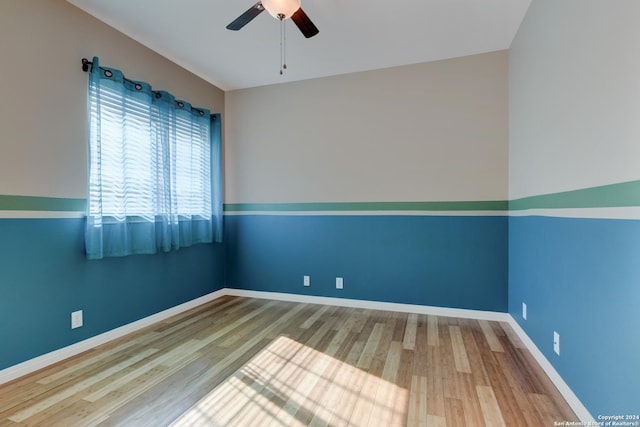 empty room with hardwood / wood-style flooring and ceiling fan