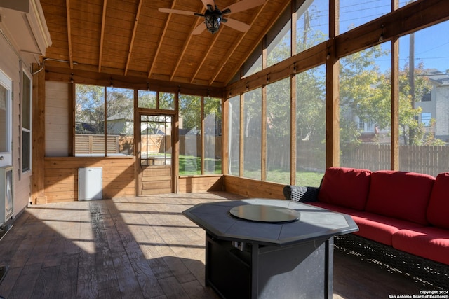 sunroom featuring lofted ceiling with beams, ceiling fan, and wood ceiling