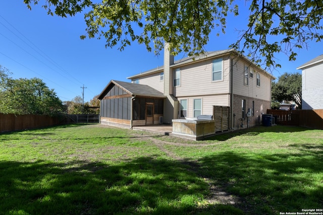 rear view of house featuring a yard, a patio area, and a sunroom