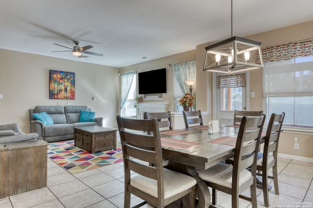 dining space with ceiling fan with notable chandelier and light tile patterned floors