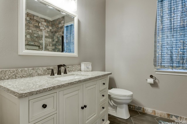 bathroom featuring tile patterned flooring, vanity, ornamental molding, and toilet