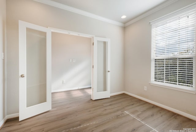 unfurnished bedroom with french doors, ornamental molding, and light wood-type flooring