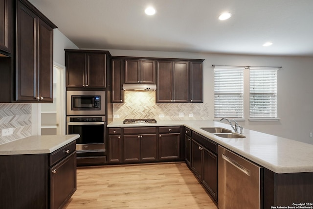 kitchen with tasteful backsplash, dark brown cabinetry, stainless steel appliances, sink, and light hardwood / wood-style floors