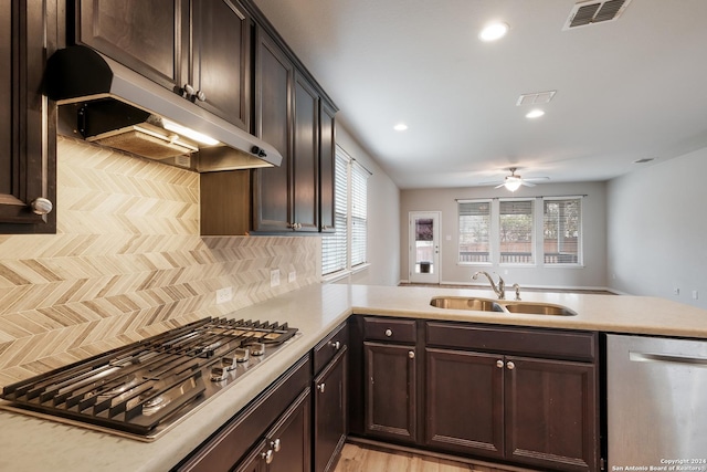 kitchen with ceiling fan, sink, kitchen peninsula, decorative backsplash, and appliances with stainless steel finishes