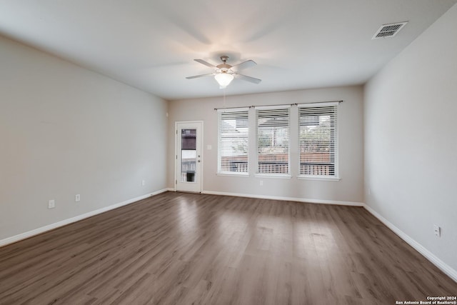 unfurnished room with dark hardwood / wood-style floors and ceiling fan