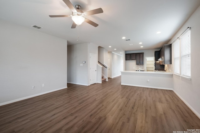 unfurnished living room featuring ceiling fan and dark wood-type flooring