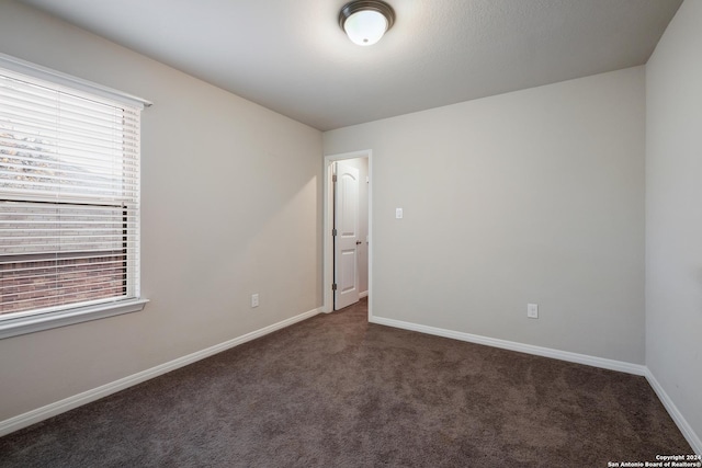 empty room featuring dark carpet