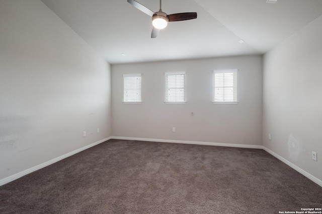 carpeted spare room featuring ceiling fan, a wealth of natural light, and vaulted ceiling