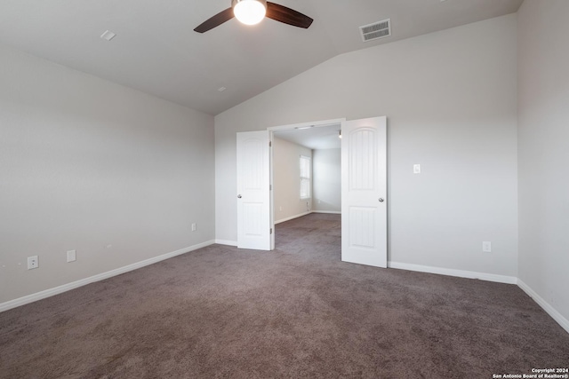 unfurnished bedroom featuring dark colored carpet, vaulted ceiling, and ceiling fan