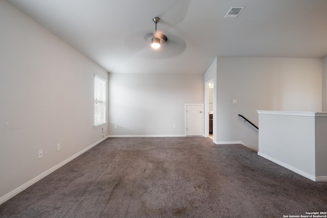 unfurnished room with dark carpet and ceiling fan