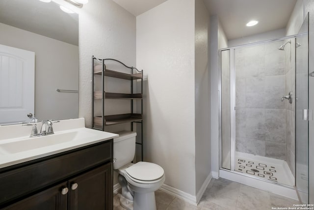 bathroom featuring tile patterned flooring, vanity, a shower with door, and toilet