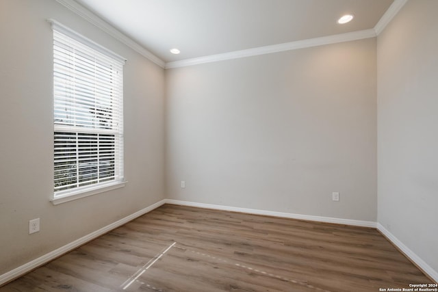 spare room featuring hardwood / wood-style floors and crown molding