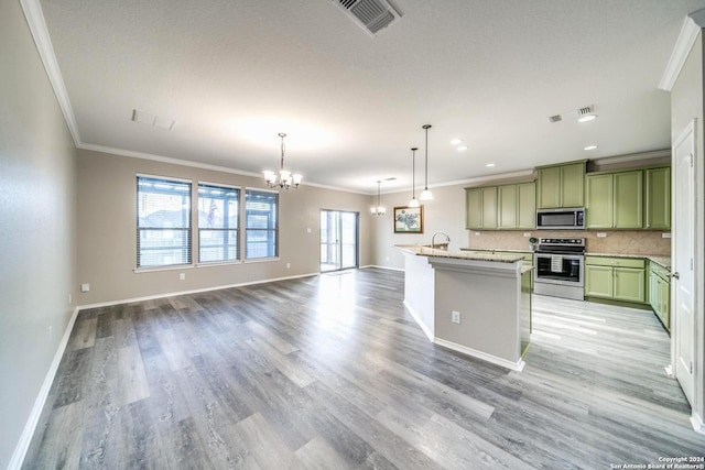 kitchen with pendant lighting, a wealth of natural light, light stone countertops, and appliances with stainless steel finishes