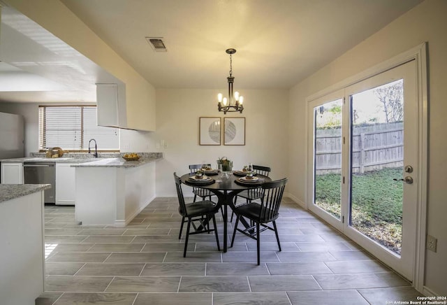 dining area featuring sink and an inviting chandelier