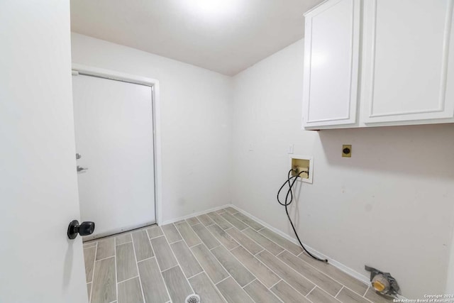 washroom featuring cabinets, hookup for a washing machine, light hardwood / wood-style floors, and hookup for an electric dryer