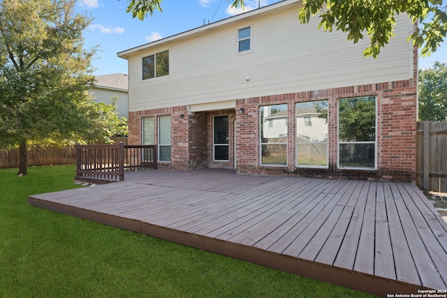 back of property with a lawn and a wooden deck