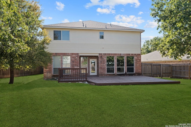 back of house with a deck and a lawn